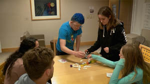 Five children work together with dominoes around a table