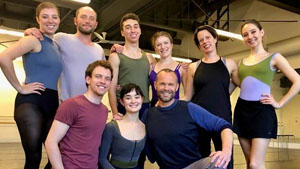 Rob kneels in front of a row of ballet dancers