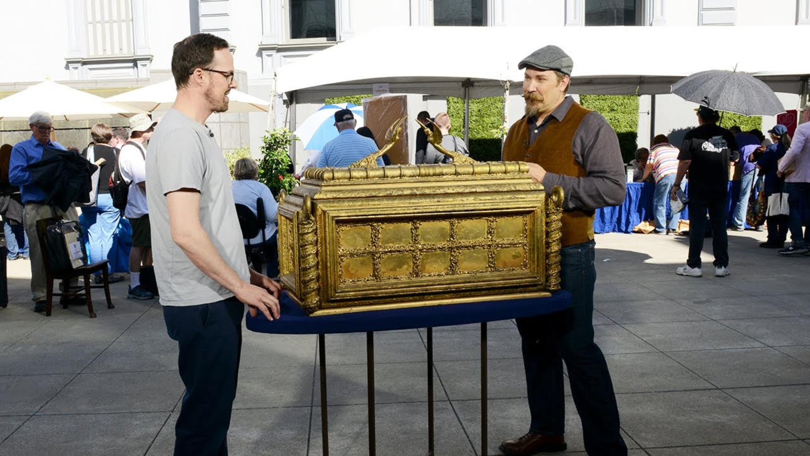 Two men standing next to 'Raiders of the Lost Ark' movie prop