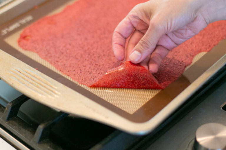 Peeling fruit leather off of a cookie sheet.